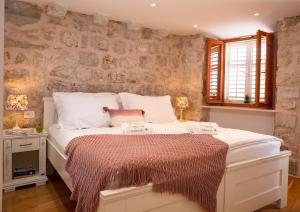 a bedroom with a large white bed with white pillows at Imperia - Chic! place with balcony in Dubrovnik