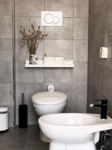 uma casa de banho com um WC branco e um lavatório. em Dèpendance immersa tra gli ulivi em Cologna