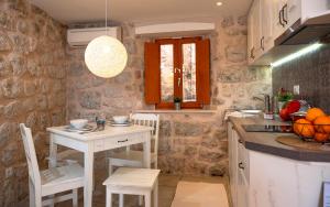 a kitchen with a table and a small table and chairs at Imperia - Chic! place with balcony in Dubrovnik