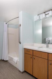 uma casa de banho com um lavatório, uma banheira e um chuveiro em WorldMark Anaheim em Anaheim