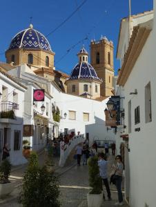 a group of people walking down a street with buildings at BellAltea in Altea