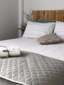 uma grande cama branca com duas almofadas em Dèpendance immersa tra gli ulivi em Cologna