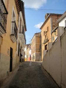 una calle vacía en un callejón entre edificios en La Casina de Piedra ENCANTO - Parte Antigua de Cáceres, en Cáceres