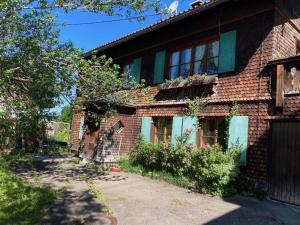 una casa de ladrillo con un balcón con flores. en Knusperhäusle Reckenberg, en Bad Hindelang