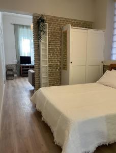 a bedroom with a bed and a brick wall at ak apartments in Athens
