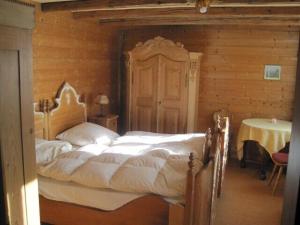 a bedroom with a large bed in a wooden room at Knusperhäusle Reckenberg in Bad Hindelang