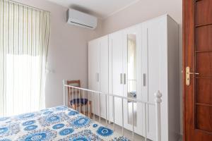 una camera con letto, armadio e specchio di Solemar Sicilia - Casa Butera a Bagheria