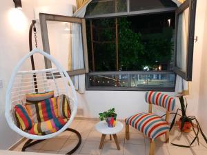 a porch with a swing and two chairs and a window at Pleno centro in San Juan