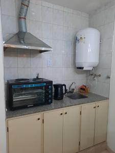 a small kitchen with a microwave and a sink at Pleno centro in San Juan