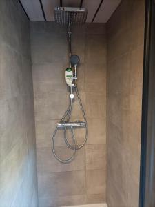 a shower with a hose in a bathroom at Pension & Ferienwohnungen Haus Edelweiß in Holzgau