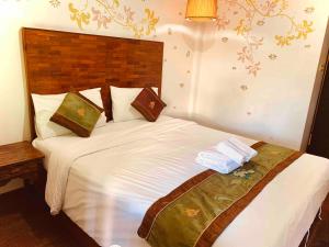 ein Schlafzimmer mit einem großen weißen Bett mit Handtüchern darauf in der Unterkunft Thapae Boutique House in Chiang Mai
