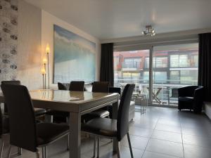 uma sala de jantar com mesa e cadeiras em Sea Horse 0401 em Nieuwpoort