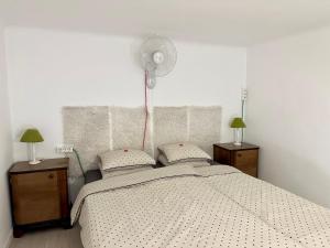 a bedroom with a bed with two lamps and a fan at Twenty2 Apartment in Budapest