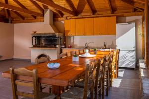 a large kitchen with a wooden table and chairs at Villa David Heraklion in Kavrokhórion