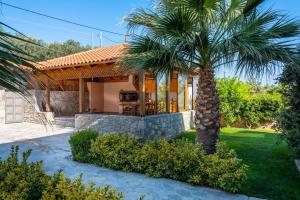 a house with a palm tree in front of it at Villa David Heraklion in Kavrokhórion