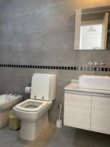 a bathroom with a white toilet and a sink at Opera Villa Carlos Paz in Villa Carlos Paz