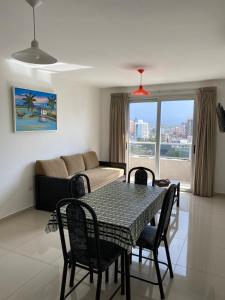 a living room with a table and chairs and a couch at Opera Villa Carlos Paz in Villa Carlos Paz