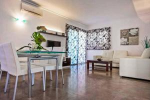 穆羅海灘的住宿－Villa Mediterraneo，客厅配有玻璃桌和白色椅子
