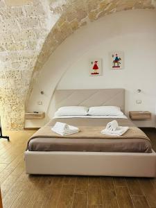 1 dormitorio con 1 cama con 2 toallas en A Quattro di Mazze, en Trapani