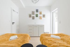 two beds in a room with white walls at Sun&Sport Apartament MAJA z ogródkiem in Szczyrk