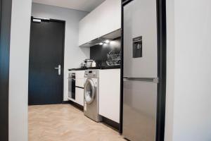 a kitchen with a washing machine and a washer at Onyx Studio Apartment in Cape Town