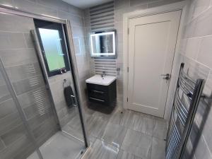 a bathroom with a shower and a sink and a door at Home Close to Center Parcs Longford 