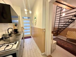 una cocina con fregadero y fogones y una escalera en Twenty2 Apartment en Budapest