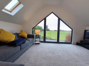 a living room with a couch and a large window at Home Close to Center Parcs Longford 