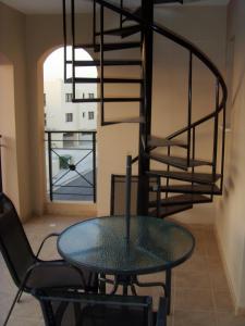 a glass table and chair in a room with a spiral staircase at Mazotos Panoramic Village in Mazotos