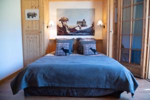 a bedroom with a bed with a blue blanket at Montana Chalet Hôtel & Spa in Le Sauze