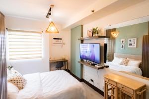 宿霧市的住宿－Grand Residences Cebu ETB - Near IT Park and Ayala Cebu，一间卧室配有两张床和一台平面电视