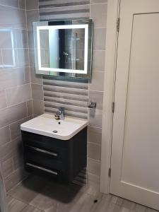 a bathroom with a sink and a mirror at Home Close to Center Parcs Longford 