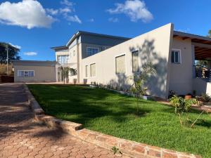 a house with a green lawn in front of it at Gletwyn Boutique Guesthouse in Harare
