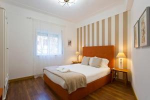 een slaapkamer met een groot bed en een raam bij APOSENTUS - Serenity 1D in Porto