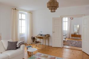 a living room with a white couch and a desk at Alter Pfarrhof Egg in Hermagor