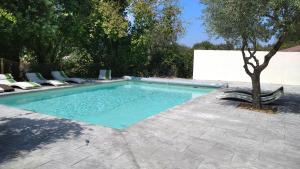 a swimming pool with chairs and a tree in a yard at Demeure du Dragon 5 chambres Piscine- 10 lits - personnes in Saint Jean du Pin