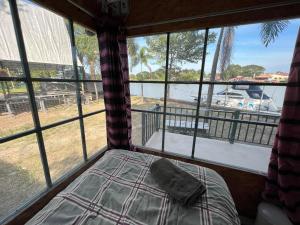 a bed in a room with a view of the water at ayutthaya river camp and yacht charter 