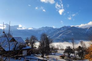 a view of a snowy mountain range with a house at Chalet Mounette Ski Sauna Lac Embrun in Puy-Sanières
