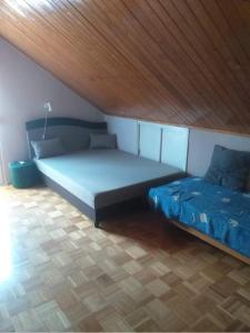 a bedroom with two beds and a wooden ceiling at AN-TA Nyaraló Harkány in Harkány