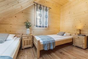 a bedroom with two beds in a wooden cabin at Pienińska Przystań in Kluszkowce