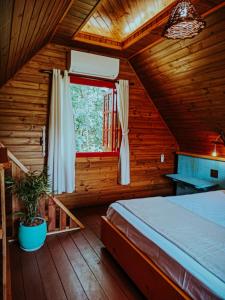 a bedroom with a bed in a wooden cabin at Locanda 65 - Serra Gaúcha in Garibaldi
