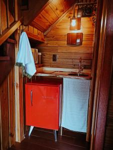 a kitchen with a sink and a red cabinet at Locanda 65 - Serra Gaúcha in Garibaldi