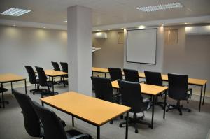 a conference room with tables and chairs and a whiteboard at Merchant Business Class Hotel in Henley on Klip