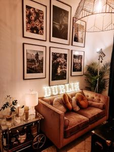 a living room with a brown couch and pictures on the wall at Whole Stylish Apartment 1880s Guinness Worker House in Dublin