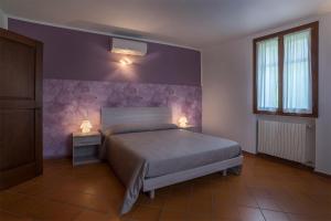 1 dormitorio con 1 cama y 2 lámparas en 2 mesas en Villaggio Della Salute Più, en Monterenzio