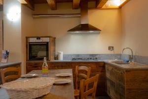 a kitchen with a table with chairs and a sink at Inn Aosta Apartments in Aosta
