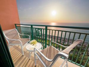 a balcony with two chairs and a table and the ocean at Atlantis, The Palm in Dubai