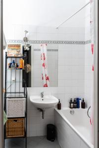 ein weißes Badezimmer mit einem Waschbecken und einer Badewanne in der Unterkunft Altbauschatz am Alsergrund, Nähe Innere Stadt in Wien