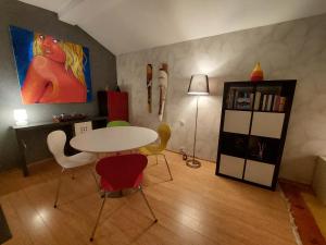 ein Esszimmer mit einem Tisch, Stühlen und einem Gemälde in der Unterkunft La crique de l'evole in Neuenburg