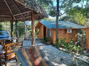 uma cabana de madeira com uma rede de descanso em frente em Eco-Turismo Guayacanes em Sámara